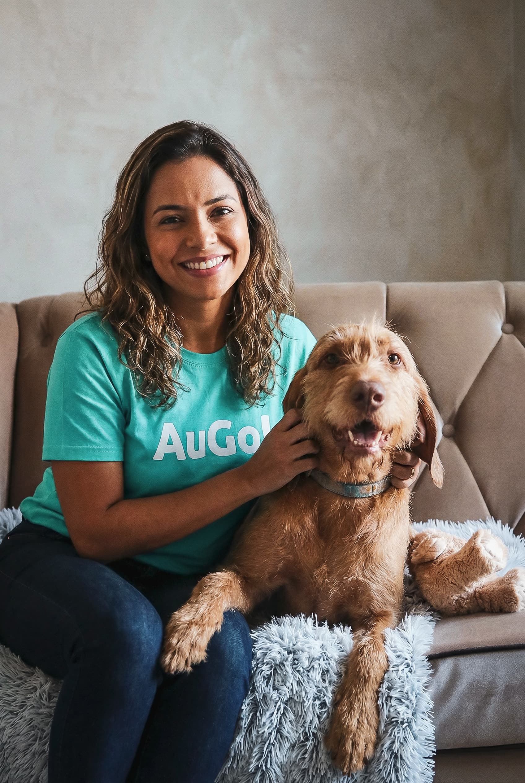 Cuidadora AuGo com um cachorro no sofá